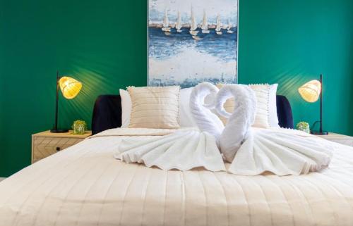 two white swans are sitting on a bed at Regent Grand Penthouse in Brighton & Hove