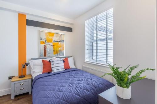 a bedroom with a purple bed and a window at Bright cheery 4 bd apartment by Brighton Station in Brighton & Hove