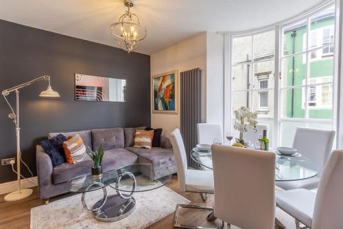 a living room with a couch and a glass table at Bright cheery 4 bd apartment by Brighton Station in Brighton & Hove