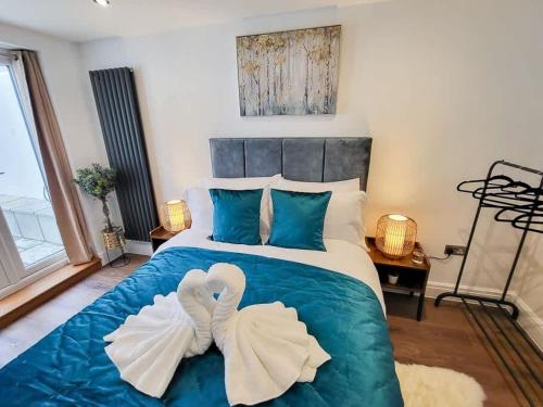 two swans towels are sitting on top of a bed at Luxury pad centrally located near Brighton station in Brighton & Hove