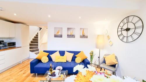 a living room with a blue couch and yellow pillows at Modern 4 bedroom flat near Brighton Station in Brighton & Hove