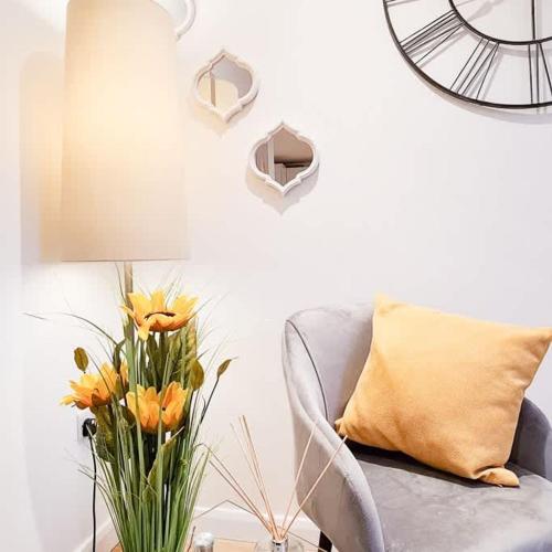 a living room with a couch and a vase of flowers at Modern 4 bedroom flat near Brighton Station in Brighton & Hove
