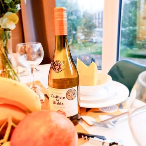 a bottle of wine sitting on top of a table at Modern 4 bedroom flat near Brighton Station in Brighton & Hove