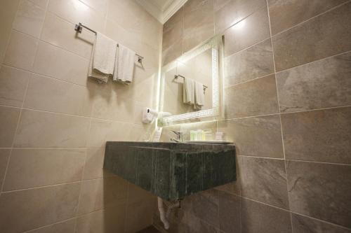 ein Badezimmer mit Steinwaschbecken und Spiegel in der Unterkunft Corner View Hotel in Wadi Musa