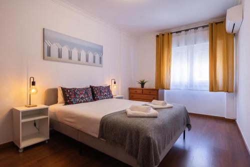 a bedroom with a bed with two towels on it at Almada Noronha 37 in Almada