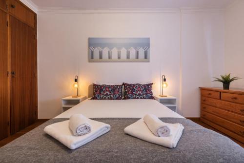 a bedroom with a large bed with two pillows on it at Almada Noronha 37 in Almada