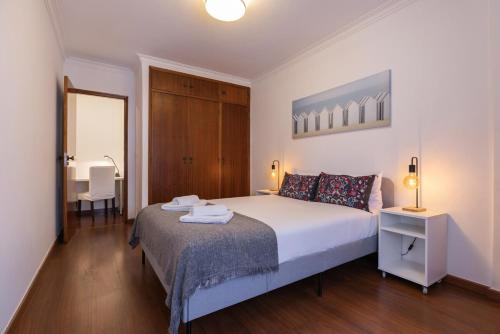 a bedroom with a bed and a table and a chair at Almada Noronha 37 in Almada