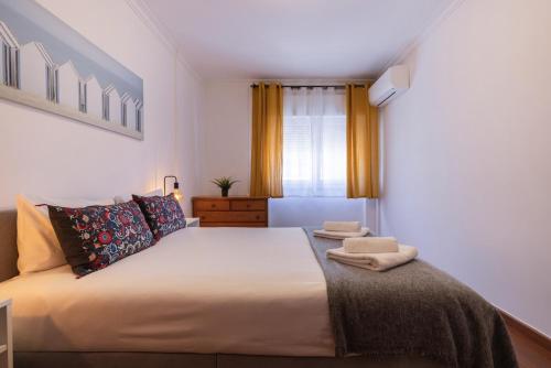 a bedroom with a large bed with two towels on it at Almada Noronha 37 in Almada