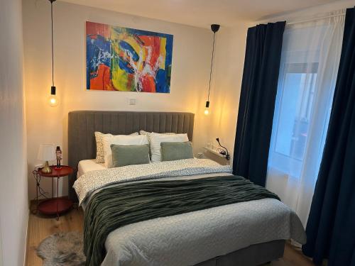 a bedroom with a bed and a painting on the wall at Apartmani Bjelovar in Bjelovar