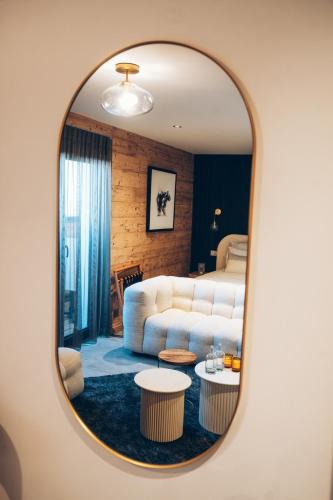 a living room with a white couch and a mirror at Chalet Nest in Les Saisies