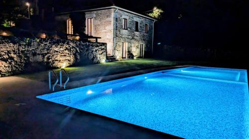 a swimming pool in front of a house at night at Quinta do Fontão - Casa com piscina in Arcos de Valdevez