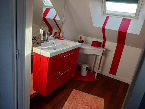 ein Badezimmer mit einem roten Schrank und einem Waschbecken in der Unterkunft Lila in Souillé