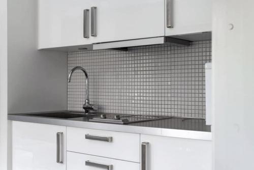 a kitchen with white cabinets and a sink at Tott vacation homes in Åre