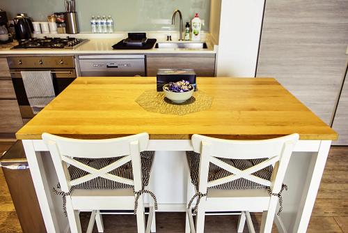a kitchen with a wooden table with two chairs at Contemporary Comfort in Melbourne