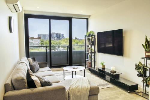 a living room with a couch and a flat screen tv at Contemporary Comfort in Melbourne