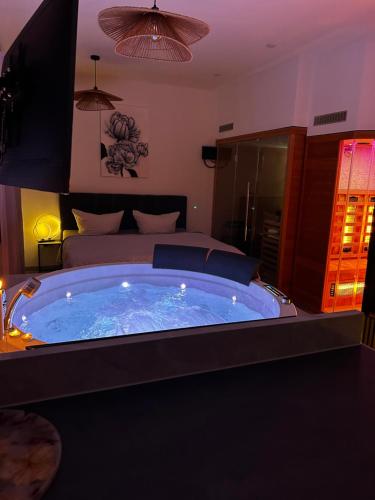 Una gran bañera de hidromasaje en un dormitorio con una cama. en PrivateSpa - Meine Wellness Oase, en Bad Schonborn