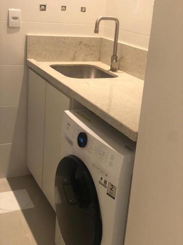 a washing machine in a kitchen with a sink at Baltico302 in Capão da Canoa