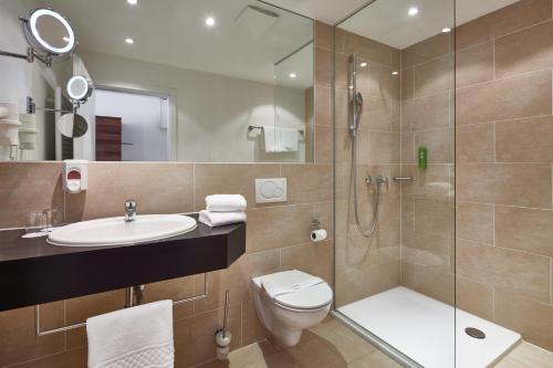 a bathroom with a toilet and a sink and a shower at ante porta DAS STADTHOTEL in Trier