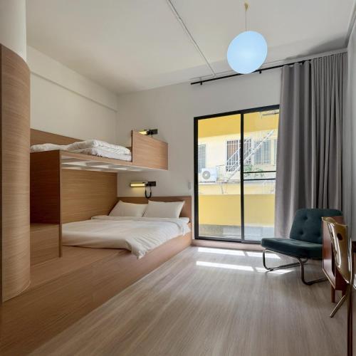 ein Schlafzimmer mit einem Bett und einem Stuhl in der Unterkunft Brown H in Pom Prap