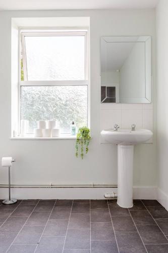 a white bathroom with a sink and a window at 2Bed by Jubilee Square Maidstone in Maidstone