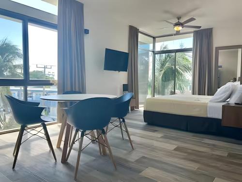a bedroom with a bed and a table and chairs at Hotel Piedra del Caribe Puerto Morelos in Puerto Morelos