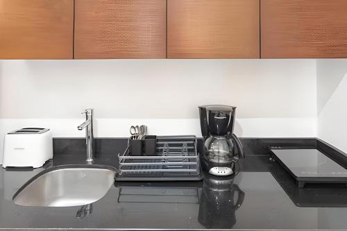 a kitchen counter with a sink and a coffee maker at Hotel Piedra del Caribe Puerto Morelos in Puerto Morelos