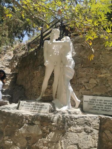 una statua di un uomo e una donna su un muro di Peyia Sunset a Peyia