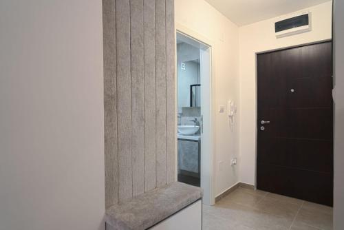 uma casa de banho com uma porta preta e um lavatório em Hedonist Garden Luxury Apartments em Doboj