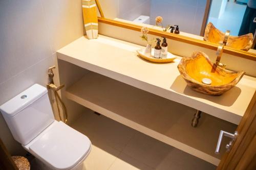 un bagno con lavandino, WC e specchio di Casa Brisa - Villa Vento a Camocim