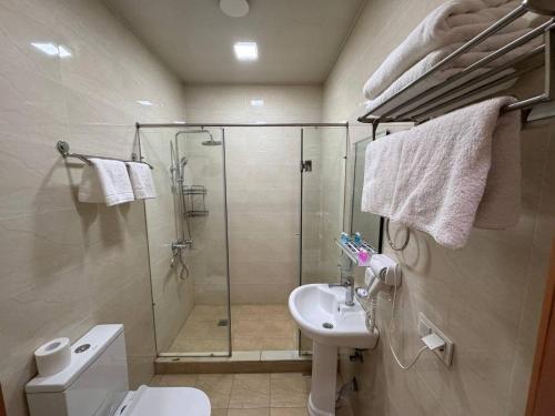een badkamer met een douche, een toilet en een wastafel bij Hotel Moon in Yakkasaray