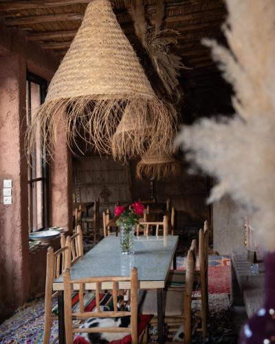 a table and chairs with a vase of flowers on it at Atlas Aura Hotel Ourika - Marrakech in Agadir nʼTafent