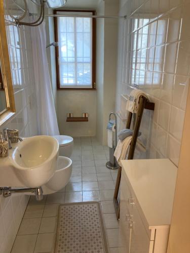 Un baño blanco con lavabo e inodoro. en Sassiglioni Vacanze, en Sassiglioni