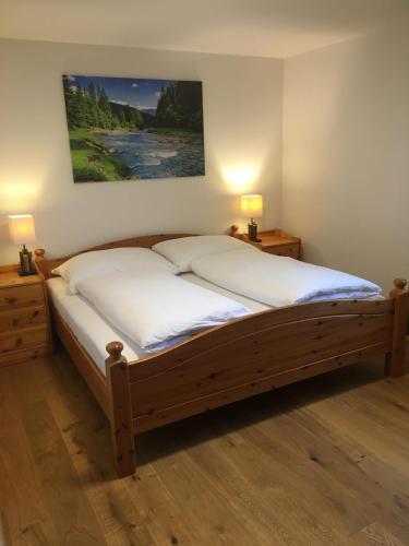 a bedroom with a large bed with two night stands and two lamps at Ferienwohnung Thöny in Vandans