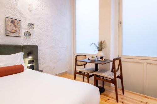 a bedroom with a bed and a table and chairs at Bainharia 82 by LovelyStay in Porto