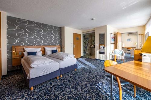 a bedroom with a bed and a desk in a room at Hotel Seehof Haltern am See in Haltern