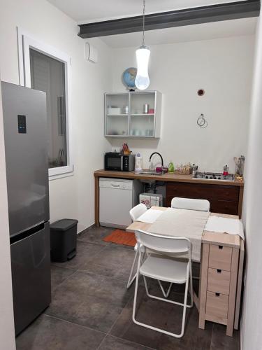 una cocina con una mesa y un refrigerador en Emilia94, en Anzola dell'Emilia