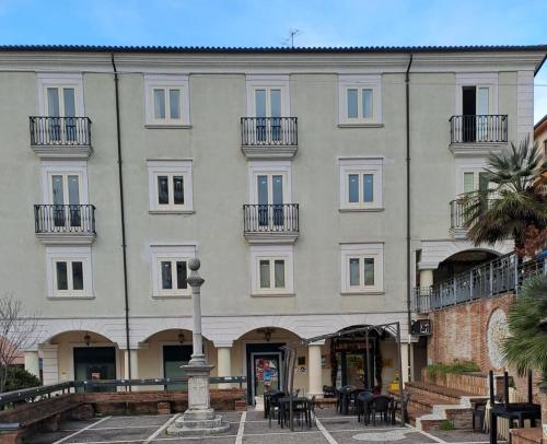 een groot gebouw met tafels en stoelen ervoor bij Piazza Duomo Guest House in Ariano Irpino