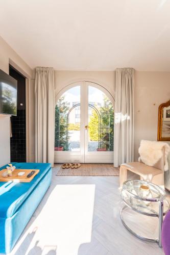 a living room with a blue couch and a table at The Gentle Arch Schiphol Amsterdam in Aalsmeer