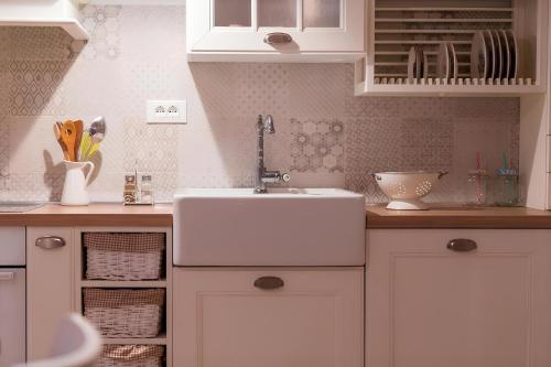 a kitchen with white cabinets and a sink at Villa Lemon & Mint in Komiža