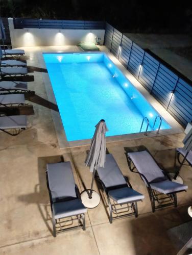 an overhead view of a swimming pool with chairs and a umbrella at Our Villa - Villa Rena in Rethymno