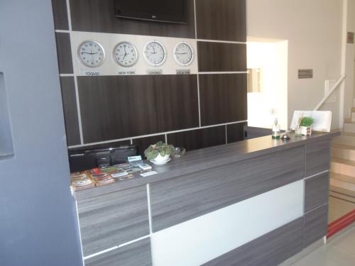 a room with clocks on the wall and a desk at Gold - Inn Hotel in Apiaí