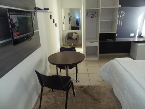 a bedroom with a table and chairs and a bed at Gold - Inn Hotel in Apiaí