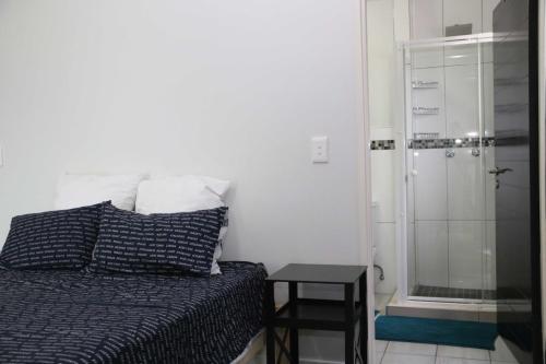 ein Schlafzimmer mit Bett und Glasdusche in der Unterkunft Lazarett Loft Modern Apartment in Windhoek
