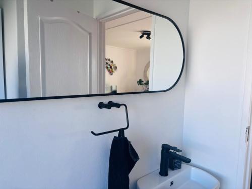 a bathroom with a mirror and a sink at Stanley's Place at 212 Salerno in Cape Town