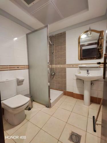 a bathroom with a toilet and a shower and a sink at فندق مواسم الاحسان توصيل مجانى للحرم in Al ‘Azīzīyah