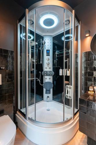 a glass shower in a bathroom with a toilet at The Gentle Arch Schiphol Amsterdam in Aalsmeer
