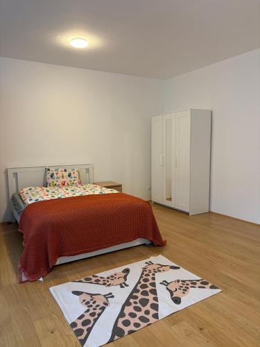 a bedroom with a bed with a giraffe rug on the floor at A bright spacious & convenient 2 brm TownHouse in Größing