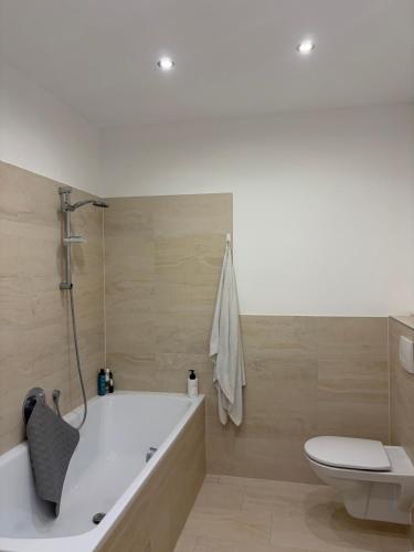 a bathroom with a tub and a toilet at A bright spacious & convenient 2 brm TownHouse in Größing