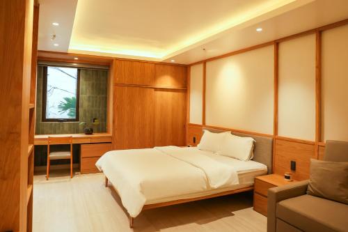 a bedroom with a bed and a desk and a window at AN Studio VVT in Ho Chi Minh City
