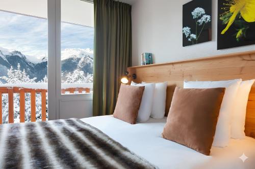 1 dormitorio con 1 cama y vistas a las montañas en SOWELL Family La Lauzière, en Aime La Plagne